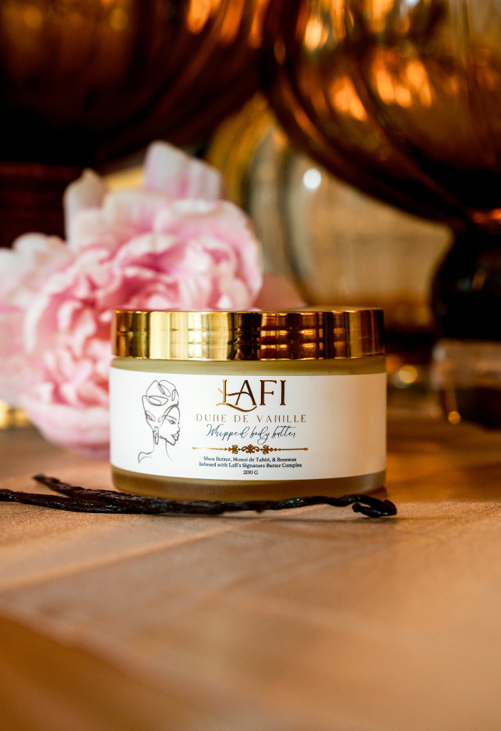 LAFI body butter jar with gold lid on a silk surface with pink flowers in the background